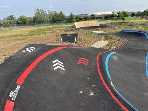 Marquage au sol avec flèches directionnelles sur une pumptrack pour sécuriser le parcours.