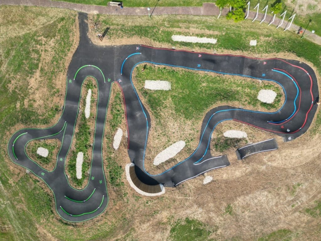 Vue aérienne complète d’une pumptrack avec marquage au sol coloré réalisé par C2 Marquage.