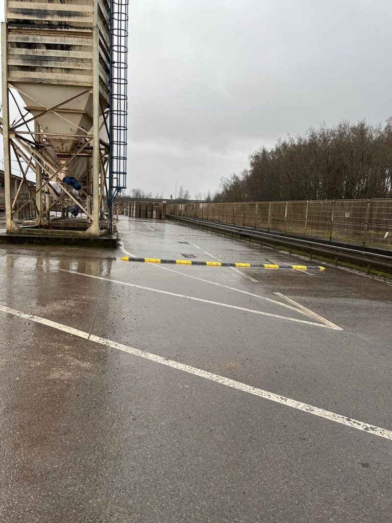 Ralentisseur modulaire noir et jaune sur voie interne industrielle en Moselle