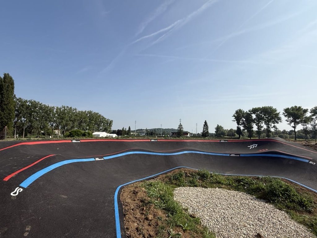 Virage relevé de pumptrack intégré dans un aménagement urbain dédié aux mobilités douces.