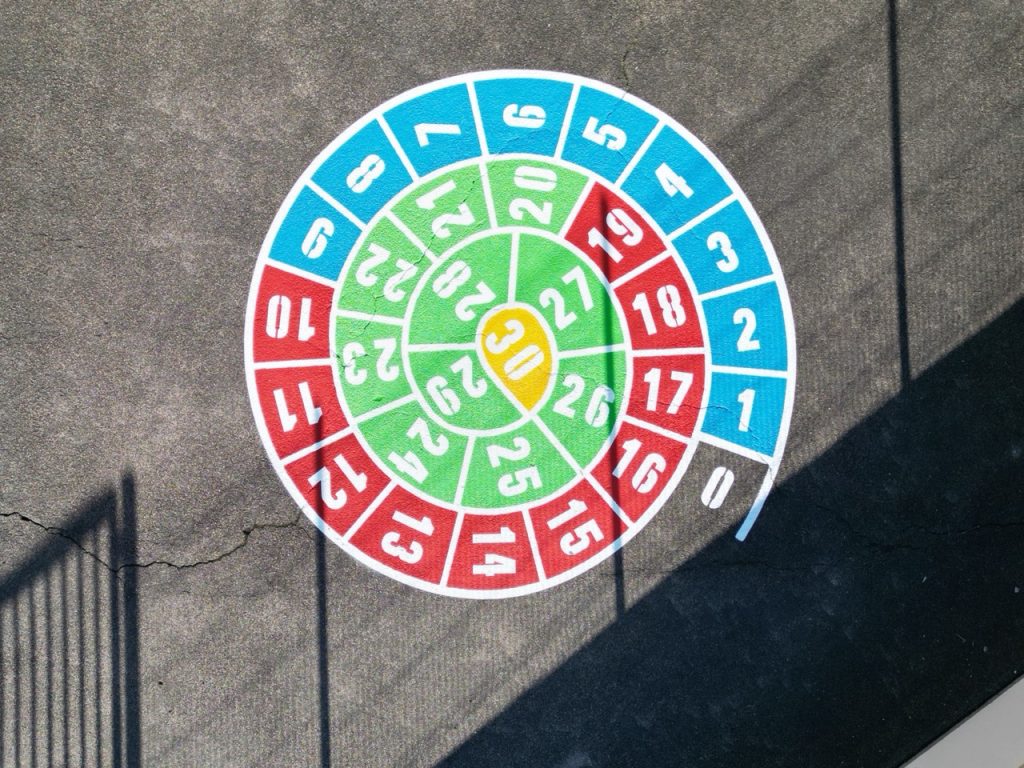 Jeu escargot coloré rouge bleu vert jaune avec chiffres de 0 à 30 pour apprentissage du calcul dans une cour d'école