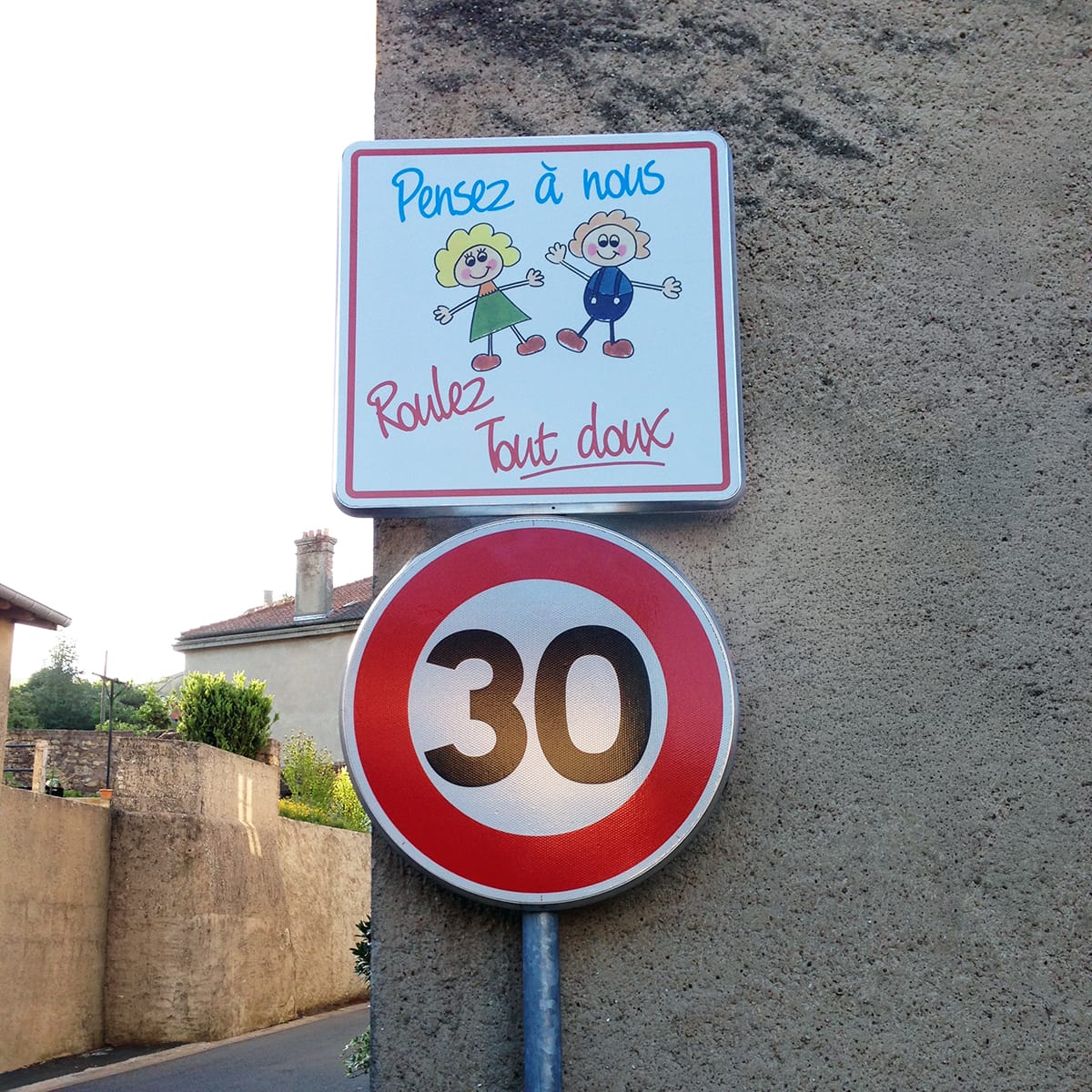 Panneau 'Roulez tout doux 30 km/h' à l'entrée d'une école pour sécuriser les abords