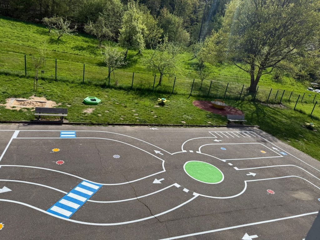 Circuit routier pédagogique avec rond-point, passages piétons et signalisation dans la cour de l'école de Hargarten-aux-Mines