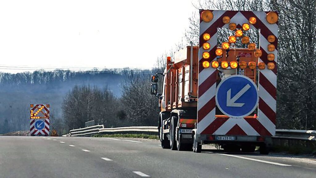 Véhicule de chantier équipé d'une signalisation lumineuse pour créer un corridor de sécurité