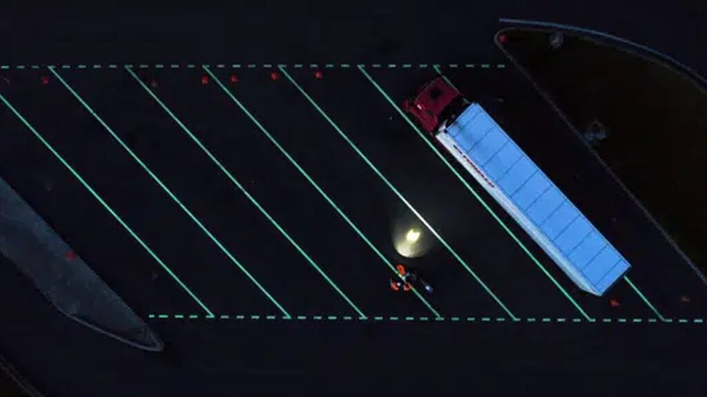 Marquage au sol photoluminescent dans un parking pour guider les véhicules la nuit