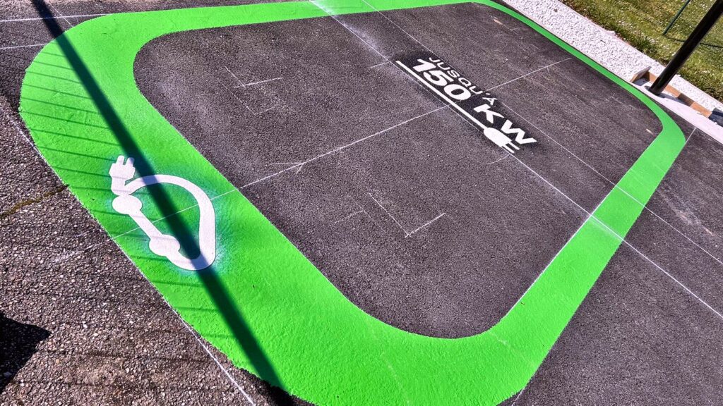Place de stationnement IRVE pour véhicule électrique avec marquage au sol vert et pictogramme véhicule électrique