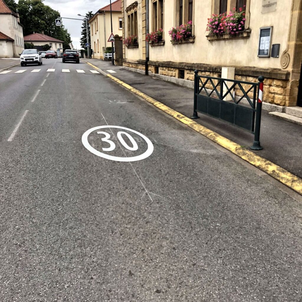 Marquage au sol rappelant la limitation de vitesse à 30 km/h en zone apaisée