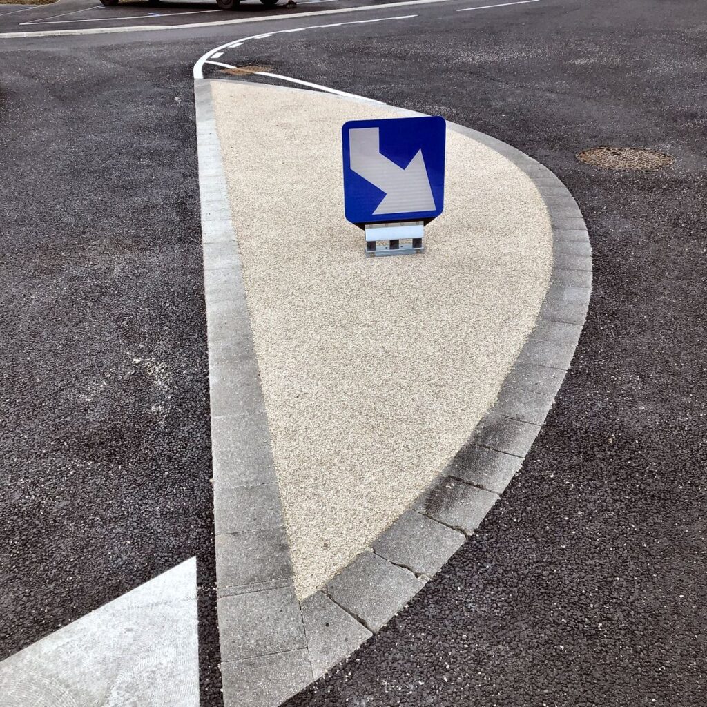 Gros plan sur la texture antidérapante d'une résine gravillonnée appliquée par C2 MARQUAGE