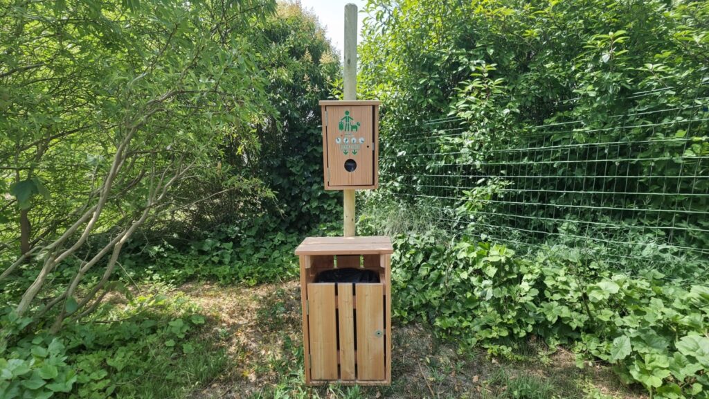 Borne de propreté canine en bois Douglas dans un espace vert