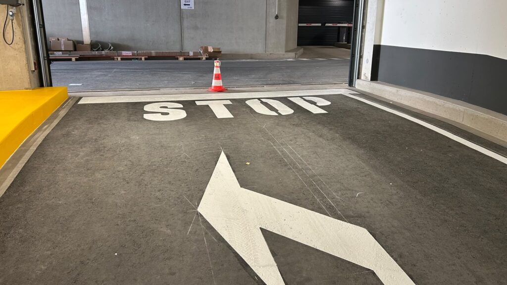 Marquage STOP et flèche directionnelle dans le parking de La Cloche d’Or