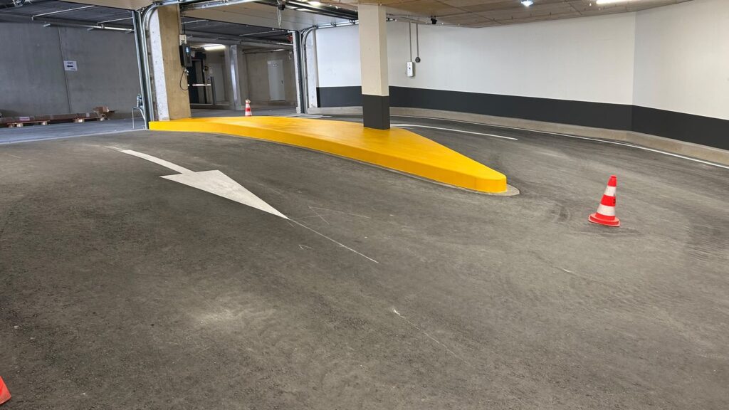 Îlot de protection mis en peinture jaune dans le parking de La Cloche d’Or