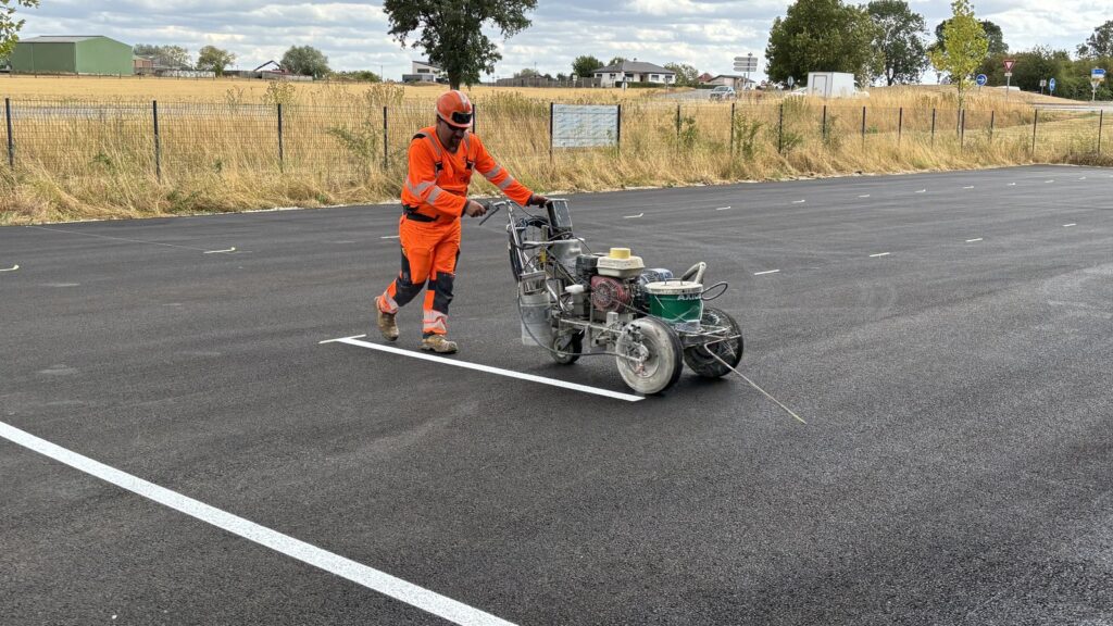 Chantier de marquage mené par temps sec sur une chaussée propre, condition nécessaire à la tenue du produit.