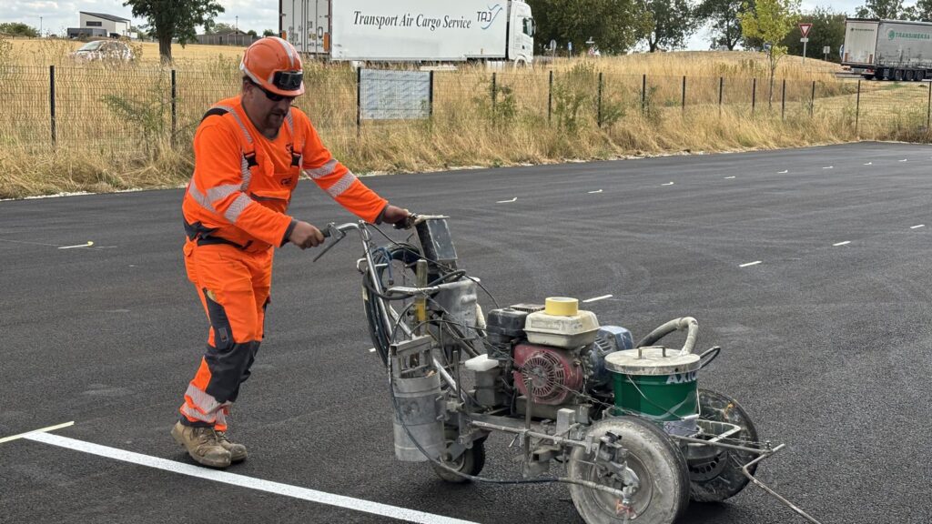 Applicateur en équipement de protection guidant la machine de marquage le long du cordeau de prémarquage.
