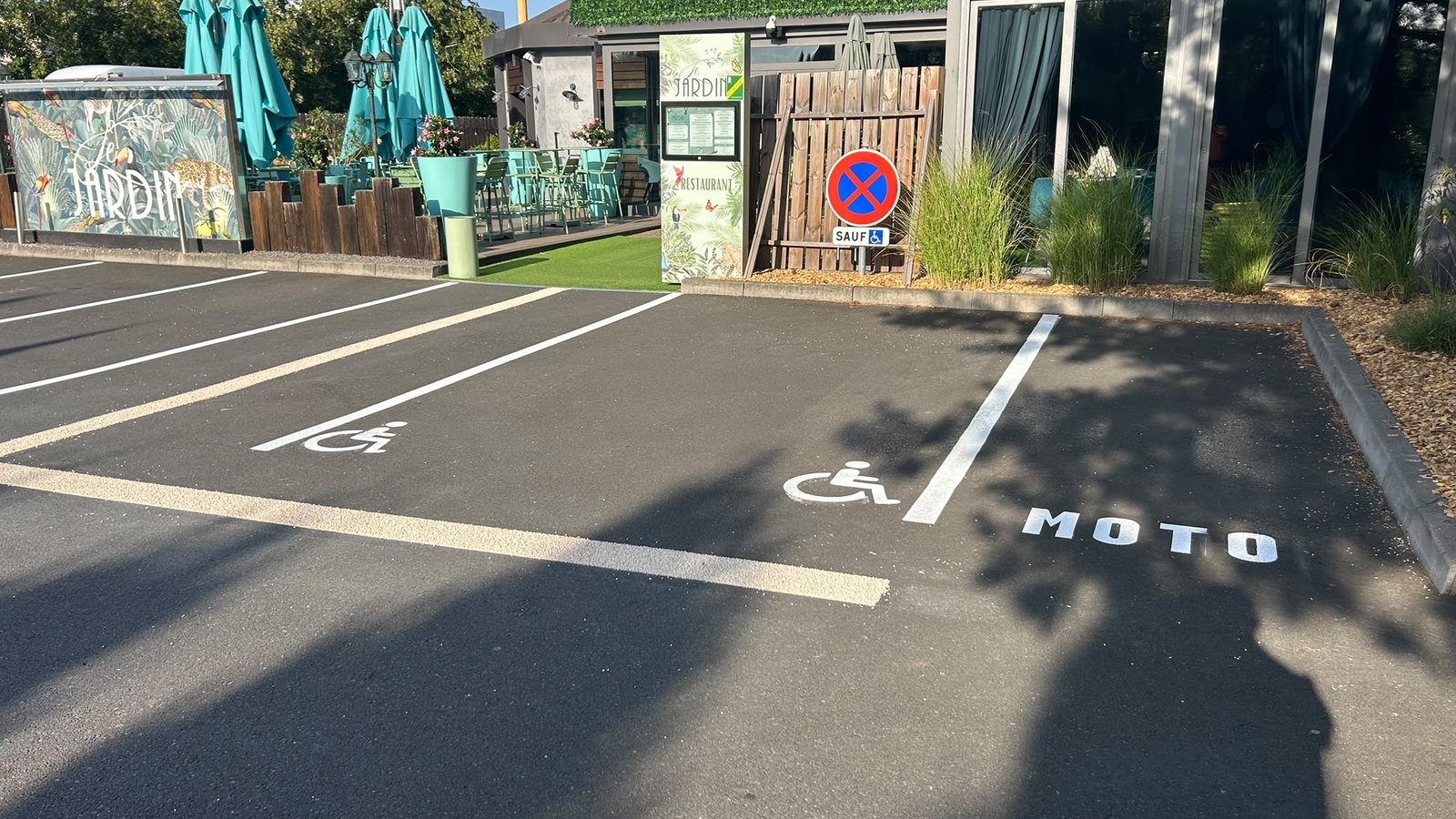Parking rénové du restaurant Le Jardin à Jouy-aux-Arches en Moselle, avec places PMR et emplacement moto.