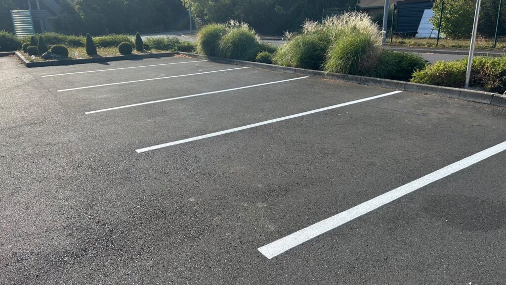 Reprise des places de stationnement en peinture routière blanche sur le parking du restaurant Le Jardin à Jouy-aux-Arches.