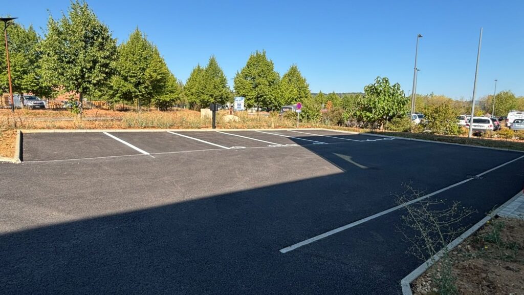 Lignes de marquage en peinture routière blanche contrastant avec l'enrobé neuf du parking de SOCOFERM.