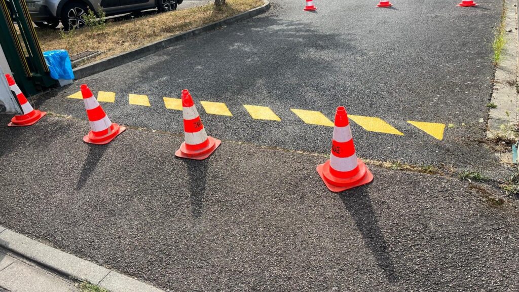 Marquage jaune en zébra délimitant une zone interdite au stationnement sur le parking d'ALYS à Ennery.