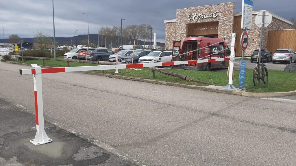 Nouvelle barrière d'accès blanche et rouge fermant une voie de parking à Jouy-aux-Arches