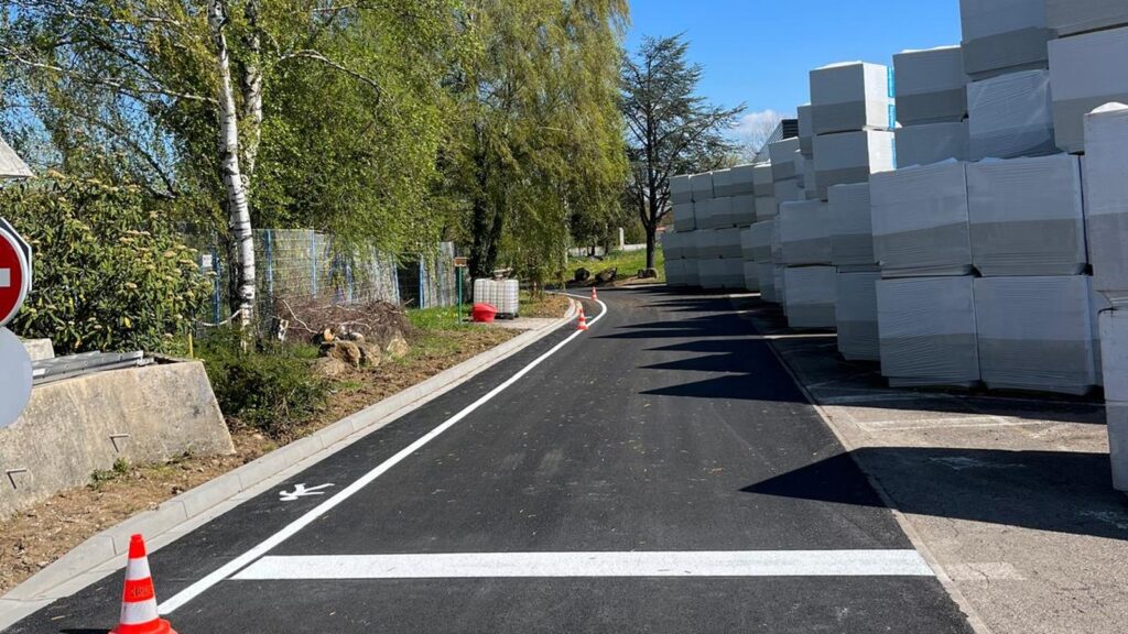 Cheminement piéton longeant des zones de stockage sur un site industriel