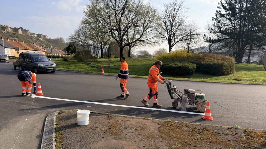 Équipe C2 Marquage réalisant le traçage des lignes à une intersection de Moyeuvre-Grande