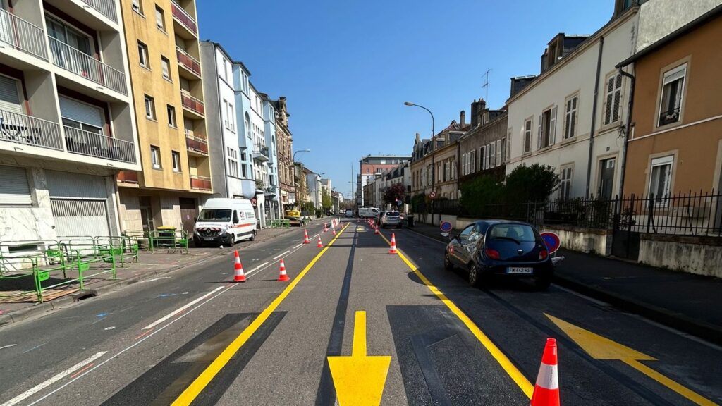 Couloir de circulation provisoire matérialisé à Metz par des lignes et des flèches jaunes, complété par des cônes de chantier