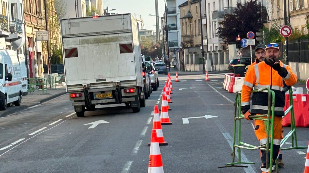 Équipe de chantier installant le balisage temporaire à Metz le long d'un couloir de circulation maintenu